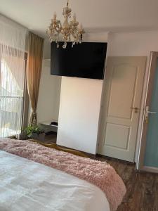 1 dormitorio con cama, lámpara de araña y puerta en Negrean Residence, en Oradea