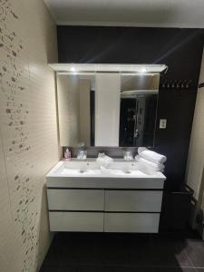W łazience znajduje się biała umywalka i lustro. w obiekcie Negrean Residence w mieście Oradea