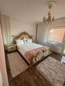 a bedroom with a large bed and a chandelier at Negrean Residence in Oradea