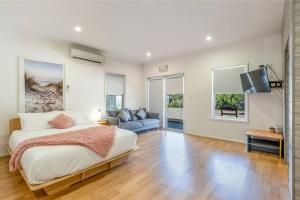 a bedroom with a bed and a couch and a tv at Gawler Townhouses 1b in Gawler