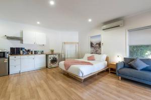 a bedroom with a bed and a blue couch at Gawler Townhouses 1b in Gawler