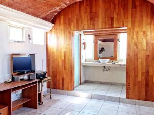 a bathroom with wooden walls and a sink and a television at Departamento Vintage Querétaro in La Cañada