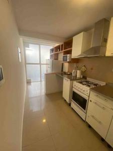 門多薩的住宿－departamento 2 dormitorios 2 baños，厨房配有白色橱柜和炉灶烤箱。