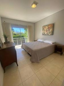Un dormitorio con una cama grande y una ventana en departamento 2 dormitorios 2 baños en Mendoza