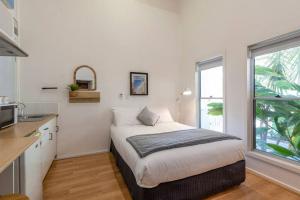 um quarto com uma cama e uma cozinha com uma janela em Gawler Townhouses 1 Bedroom (1c) em Gawler