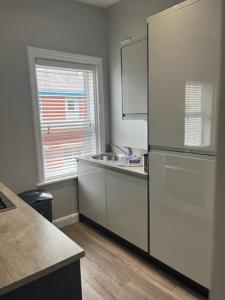 a kitchen with a refrigerator and a sink at Stanley Street Apartment in Southport