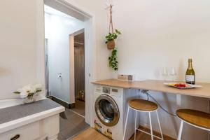 eine Küche mit einer Waschmaschine und einer Theke mit Hockern in der Unterkunft Gawler Townhouses 1 Bedroom (1c) in Gawler