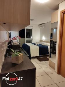 um quarto de hotel com uma cama e uma cozinha com um balcão em Flatzer047 Executivo em Caxias do Sul