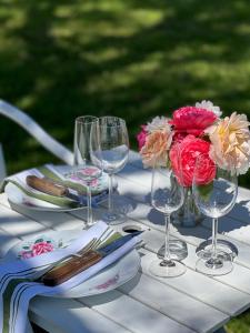 un tavolo con bicchieri da vino e un mazzo di fiori di Serenity on Stanthorpe a Fleurbaix