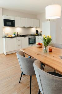 a kitchen with a wooden table and chairs at Utkiek Stuuv in Ratzeburg