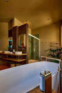 a bathroom with a shower and a sink and a tub at La Chapelle, Les Suites du Palais, l'unique 5 étoiles de Nevers, Suite d'Exception, by PRIMO C0NCIERGERIE in Nevers