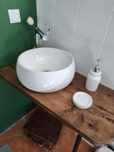 La salle de bains est pourvue d'un lavabo blanc sur une table en bois. dans l'établissement Casas do Arrabalde, à Amarante