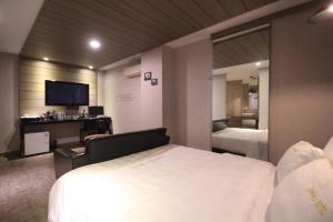 um quarto de hotel com uma cama e um espelho em Paradise Hotel em Gunsan