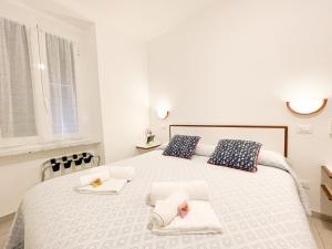 a white bedroom with a large bed with towels on it at Soggiorno Marina in Varazze