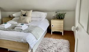 - une chambre avec un lit et 2 serviettes dans l'établissement Stylish loft apartment moments from beach by Whitstable-Holidays, Bowline, à Whitstable