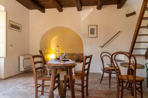a dining room with a table and chairs and a staircase at La Locanda di Emma in Maratea