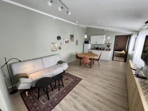 a living room with a white couch and a table at Bridge Apartment in Egilsstaðir