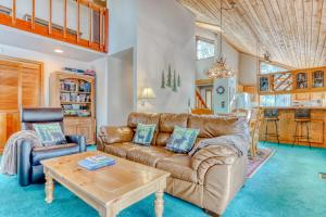 uma sala de estar com um sofá de couro e uma mesa em The Huckleberry Cabin em Sunriver