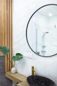 uma casa de banho com um lavatório preto e um espelho em Laguna Resort Beskidy & Wellness em Zarzecze