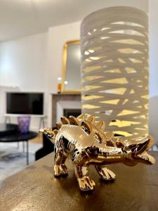 een gouden beeld van een dinosaurus zittend op een tafel bij Bel Appartement avec parking au coeur de Reims in Reims
