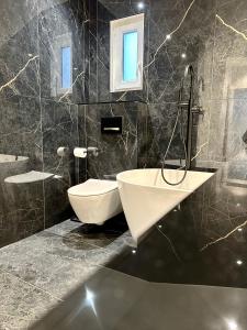 een badkamer met een bad, een wastafel en een toilet bij Bel Appartement avec parking au coeur de Reims in Reims