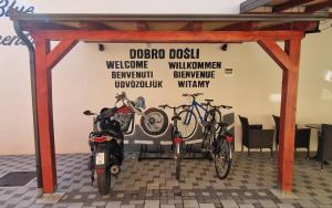 two bikes and a motorcycle parked in a garage at Design Apartments Red Blue in Osijek