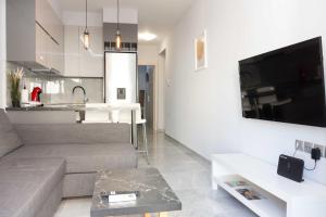 a living room with a couch and a tv and a kitchen at Luxury Apartment in Thessaloniki Centre in Thessaloniki