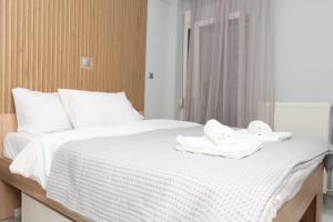 Una cama blanca con toallas encima. en Luxury Apartment in Thessaloniki Centre en Tesalónica