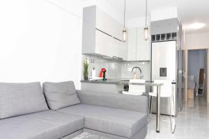 a living room with a couch and a kitchen at Luxury Apartment in Thessaloniki Centre in Thessaloniki