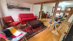 ein Wohnzimmer mit einem roten Sofa und Stühlen in der Unterkunft Selestat entre Colmar et Strasbourg in Sélestat