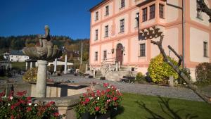 różowy budynek z fontanną przed budynkiem w obiekcie Hotel Garni Schloß Schönberg w mieście Bad Brambach