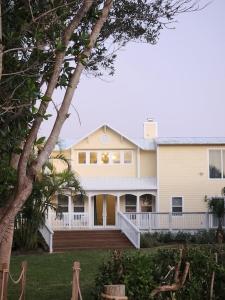 ein großes weißes Haus mit einer großen Veranda in der Unterkunft Renovated Spacious Beach House-Steps from the Beach! in Fort Pierce