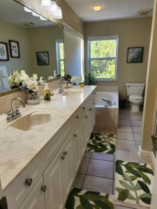 ein Badezimmer mit einem Waschbecken, einem WC und einem Spiegel in der Unterkunft Renovated Spacious Beach House-Steps from the Beach! in Fort Pierce