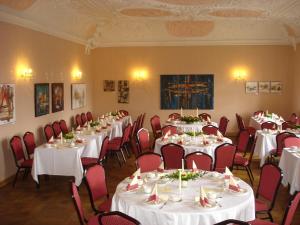 una habitación con mesas y sillas con manteles blancos en Hotel Garni Schloß Schönberg en Bad Brambach