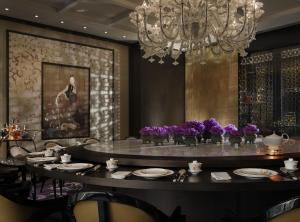 a dining room with a table and a chandelier at Rosewood Beijing in Beijing