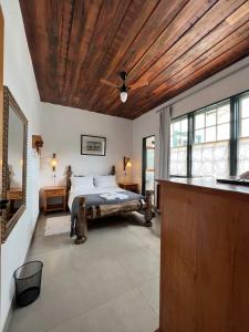 um quarto com uma cama e um tecto em madeira em Cama e Café Tiradentes em Tiradentes