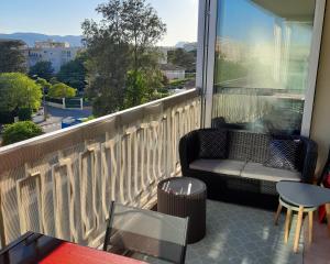 a balcony with a chair and a table and a window at Studio type T1 avec parking et cave à 600 m de la plage in Fréjus