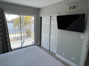 a bedroom with a bed and a flat screen tv at Marco Island Lakeside Inn in Marco Island