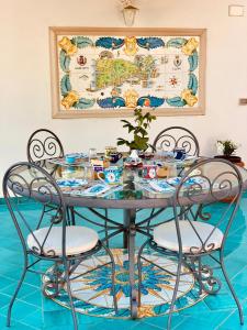 a dining room table with chairs and a map on the wall at B&B L'Agapanto in Capri