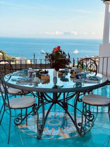 una mesa con un jarrón de flores en el balcón en B&B L'Agapanto, en Capri