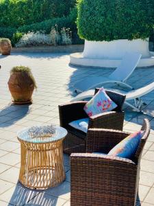 a patio with two wicker chairs and a table at B&B L'Agapanto in Capri
