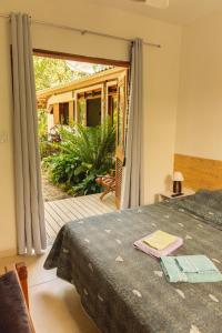 a bedroom with a bed and a sliding glass door at Suites surf house itamambuca in Ubatuba