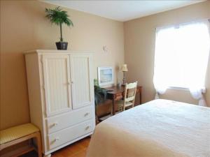 ein Schlafzimmer mit einem Bett und einer Kommode mit einer Pflanze darauf in der Unterkunft A13 Pool view, easy access MGR American Dream in Mallory Park + 11 Fotos