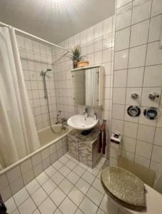 y baño blanco con lavabo y ducha. en Complete Apartment peacefully situated near the Airport Nürnberg, en Núremberg