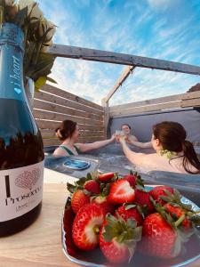 a group of people in a hot tub with a plate of strawberries at Glens glamping in Cushendall