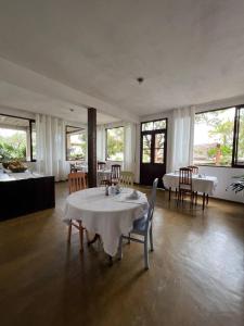 a large room with tables and chairs and windows at Cama e Café Tiradentes in Tiradentes