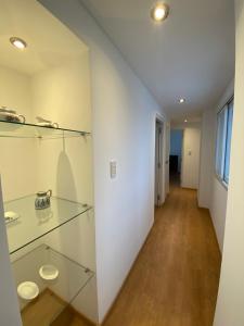 Habitación con estanterías de cristal y pasillo en Hermoso departamento de 2 habitaciones, en Salta Capital en Salta