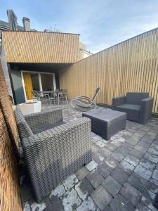 eine Terrasse mit Stühlen, Tischen und einem Zaun in der Unterkunft Ô’pti Cavens in Malmedy