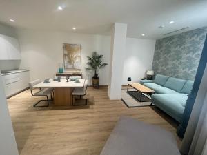 a living room with a blue couch and a table at Suites Chinitas in Málaga +21 photos