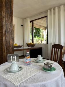uma mesa com uma toalha de mesa branca sobre uma mesa com uma toalha de mesa em Cama e Café Tiradentes em Tiradentes